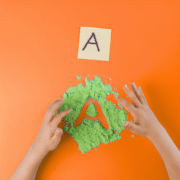 Student writing A in the sand