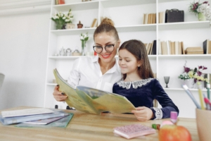 Student and tutor reading a book.